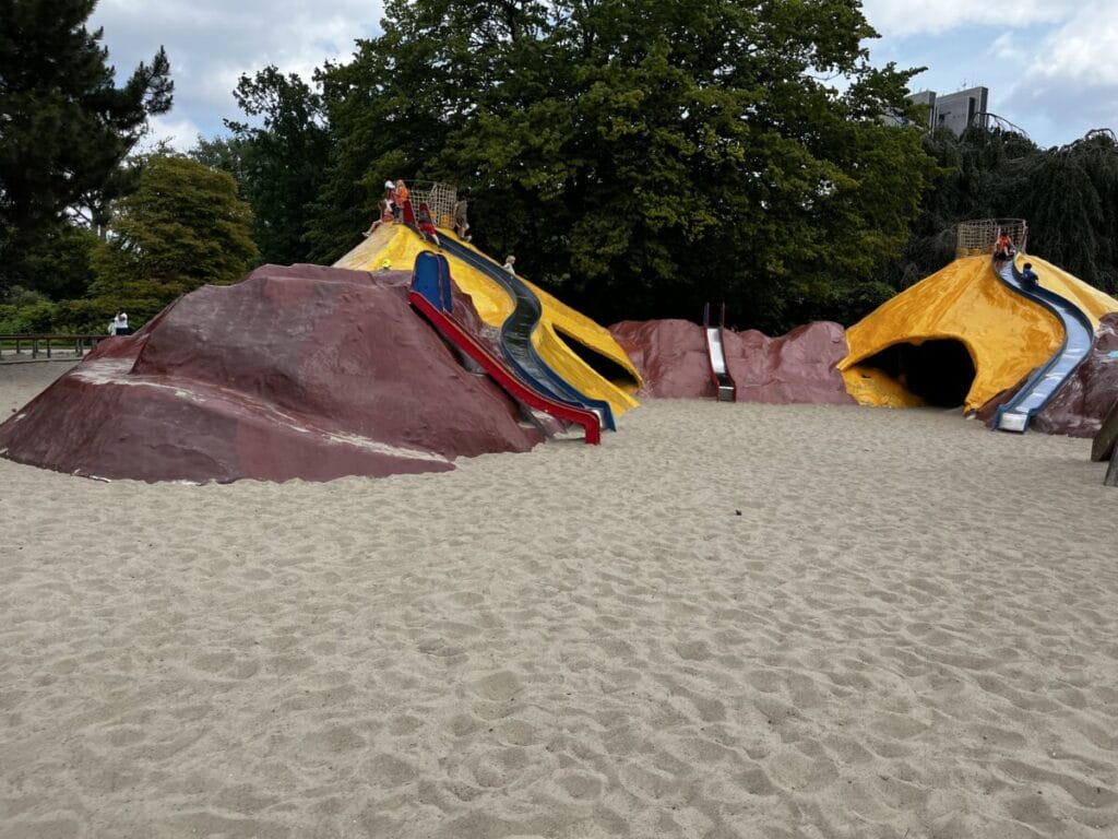 Kind rutscht am bunten Bullerberg-Spielhügel auf dem Planten und Blomen Spielplatz in Hamburg